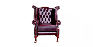 a red leather chair with wooden legs